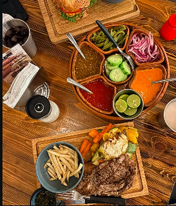 Mesa servida con salsas, papas y carne