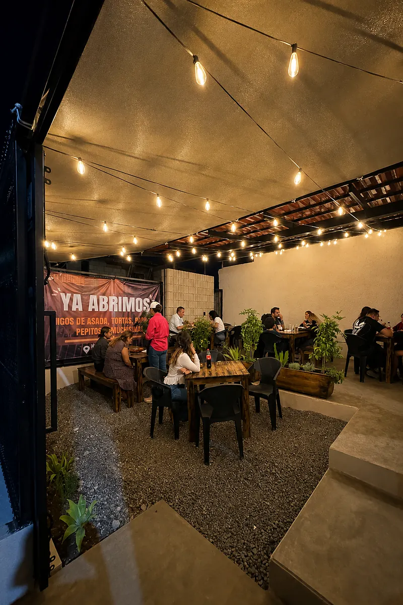 Patio al aire libre con mesas de madera y series de foquitos encendidos